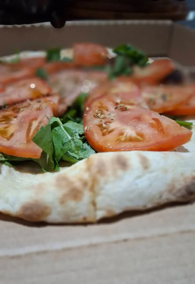 Pizza estilo napolitano con tomate y albahaca
