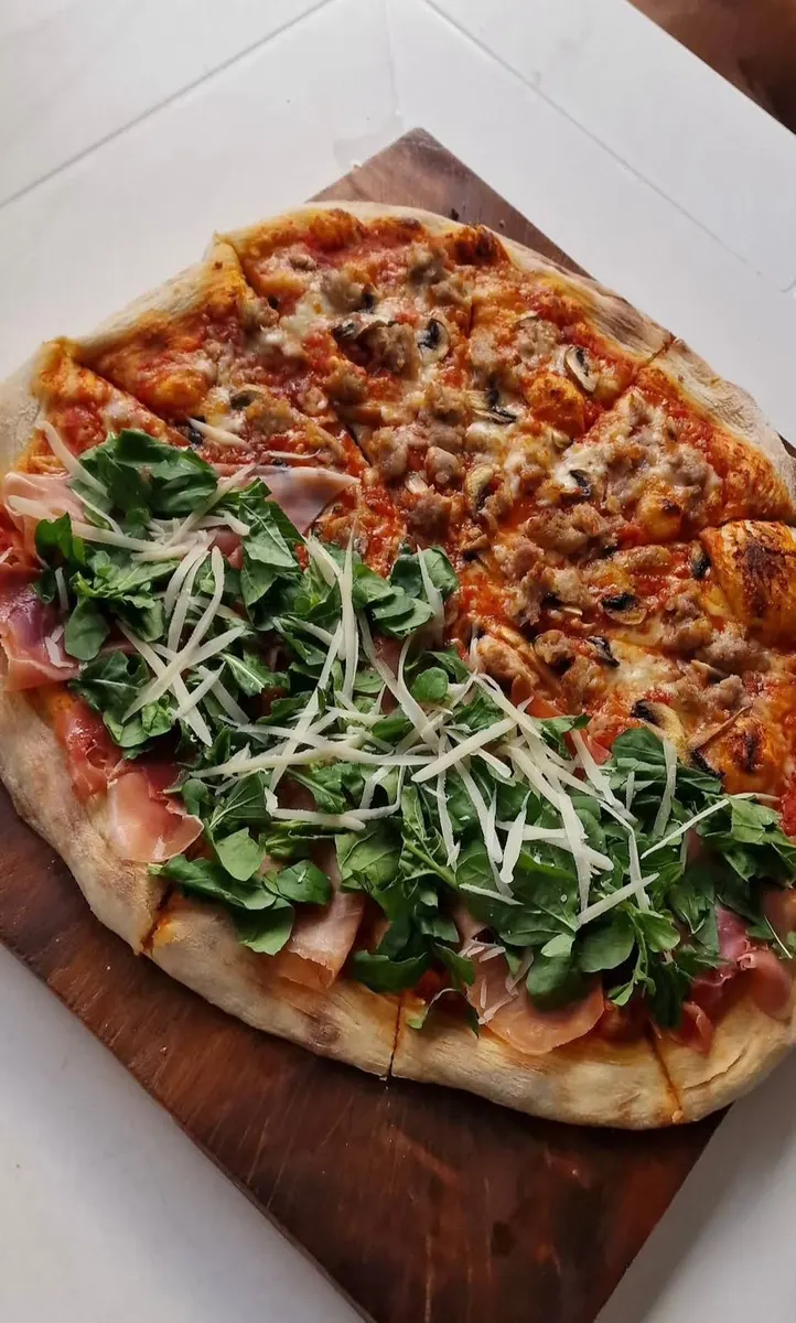 Pizza partida prosciutto y salsiccia para compartir